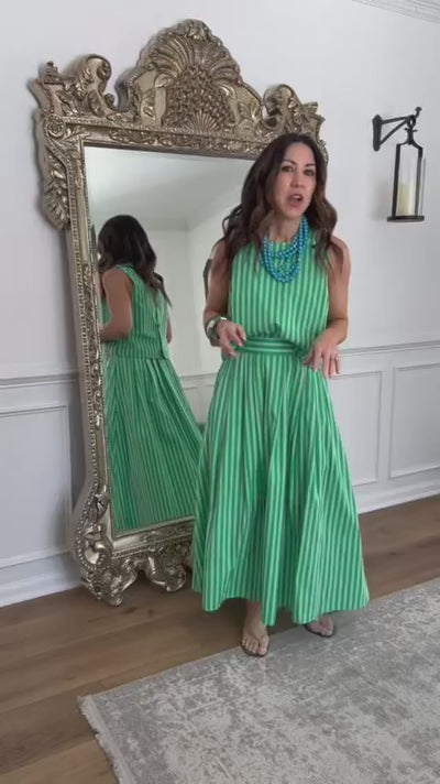 Model in green striped two piece set in front of mirror
