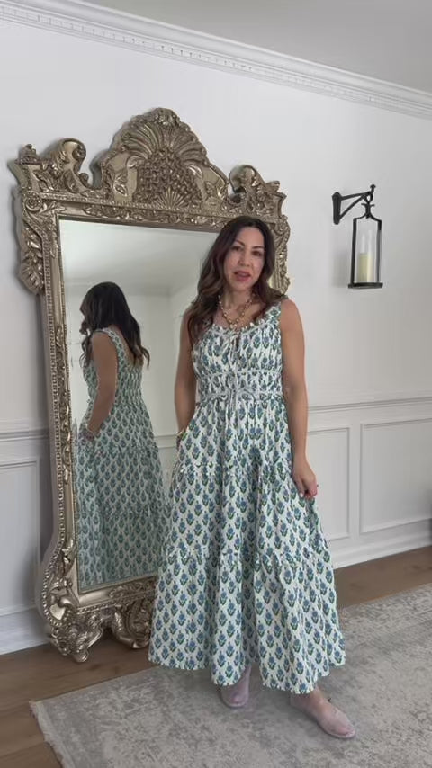 Woman talking about camilla blue floral midi dress standing in front of mirror