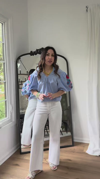 woman wearing blue striped top with mirror in background