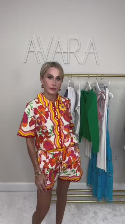 woman wearing a melissa orange set with with a rack of clothing in the background