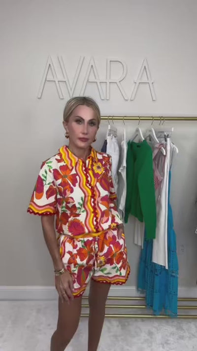 woman wearing a melissa orange set with with a rack of clothing in the background