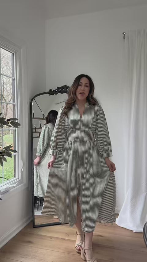 woman wearing green striped dress with mirror in background