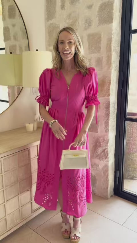 woman wearing pink emersyn dress with stone wall in background